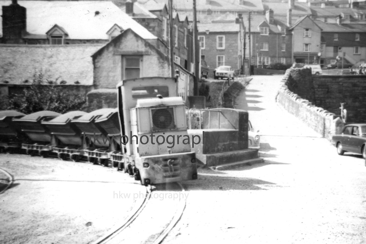 A narrow gauge train of roadstone approaches Newlyn Harbour, Cornwall UK