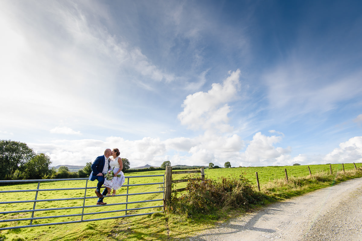 Bride and groom kissing on a 5 bar gate at The Green Cornwall