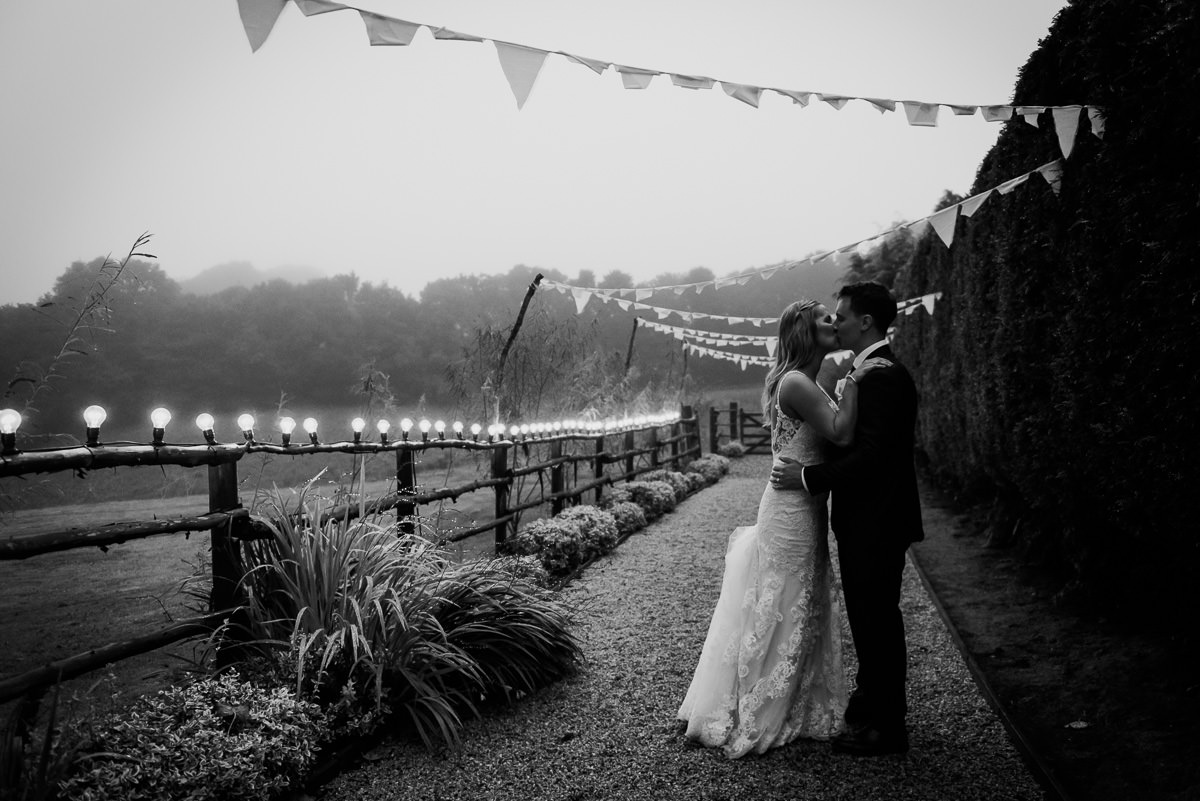 Bride and groom kissing in the Cornish mizzle