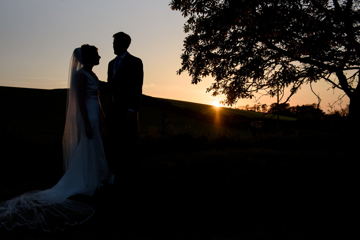 silhouette of bride and groom at sunset